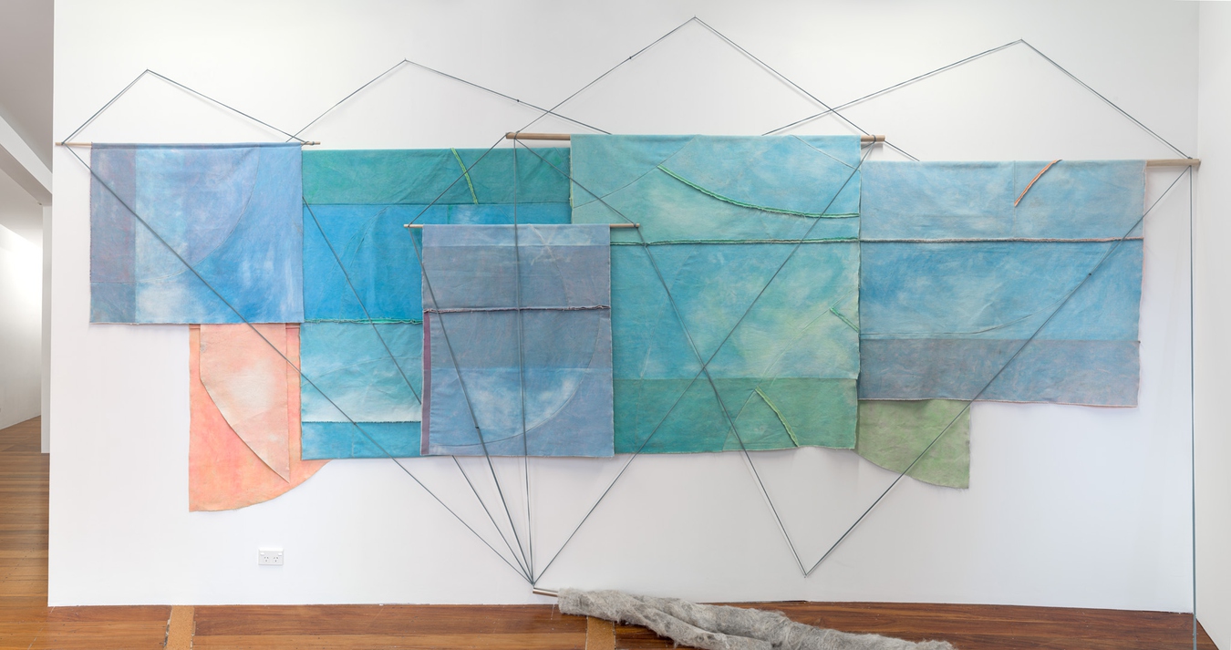 Image: Emma Fitts, From heat to translucence / your mineral touch (installation view), 2023. Weathered canvas, felted wool, aluminium and wooden rods, fabric ties. Photo by John Collie.
